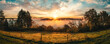 Magnificent sunrise over rural idyll. A colorful panorama with romantic, dramatic sky, sunlit fog in the valley and tree silhouettes