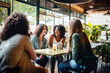 © Jasmina - Happy smiling female friends sitting in a café laughing and talking during a lunch break