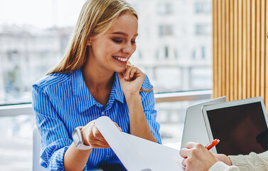 Canvas Print - Pensive young man signing working documents which holding pretty cheerful secretary.