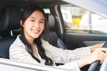 Transport concept, happy smile brunette hair asian young woman driving, getting new car, vehicle for travel, trip with face positive, female driver car with fasten safety seat belt before traveling.