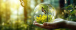 Earth crystal glass globe ball in hand with nature background.