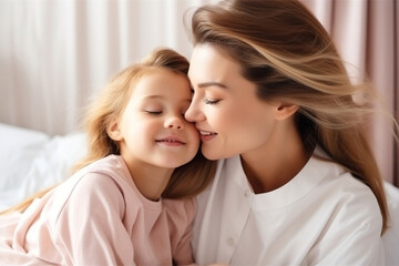 Wall Mural - Cheerful loving mom kissing pretty little daughter kid with faces, noses touch, closed eyes, cuddling child with affection, care, tenderness, enjoying motherhood, family moment