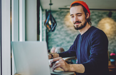 Fototapete - Positive caucasian male checking news from networks working remotely on publicity area