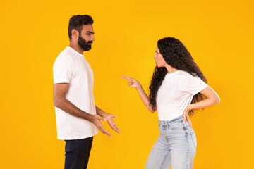 Wall Mural - Arab Lady Shouting At Husband While Arguing Over Yellow Background