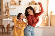 © Prostock-studio - Cheerful mother and daughter moving and dancing to music indoor