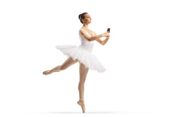 Wall Mural - Full length shot of a ballerina dancing and holding a smartphone