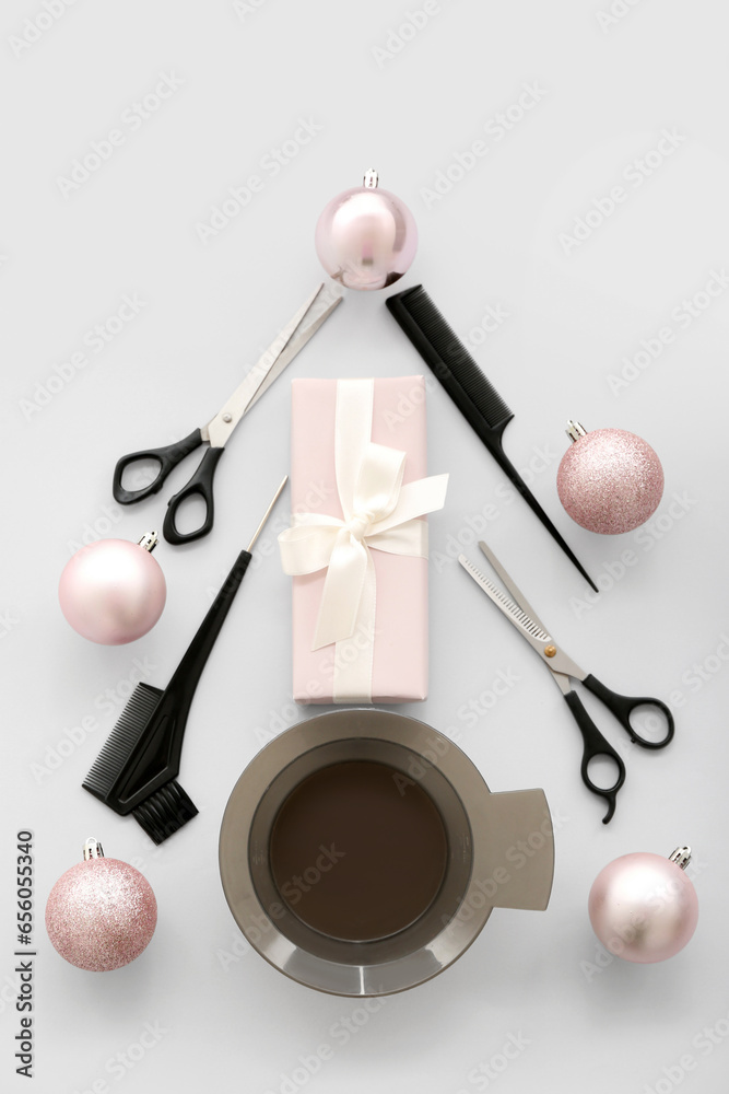 Christmas tree made of hairdressing tools, balls and gift on light background