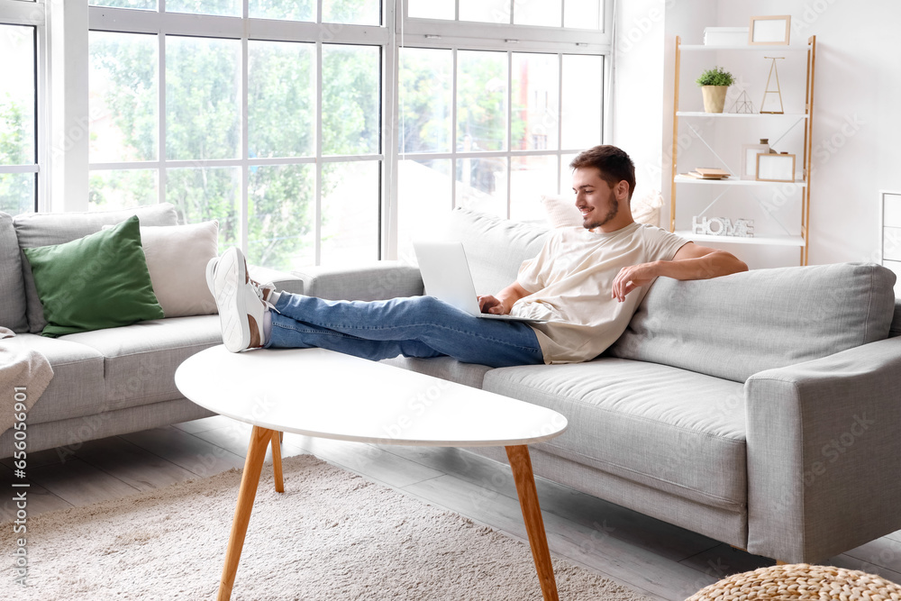 Young man using laptop on his day off at home