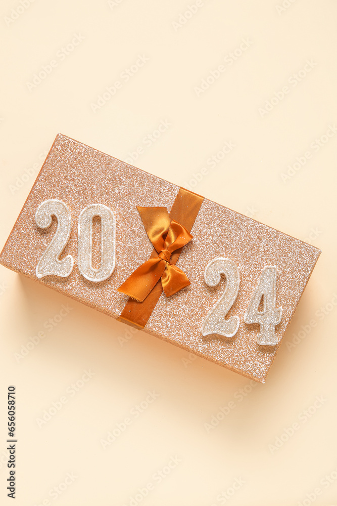 Figure 2024 with gift box on beige background