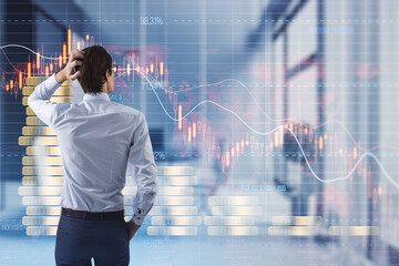 Poster - Back view of thoughtful man looking at creative forex chart hologram with declining stacked coins on blurry office interior background. Financial recession, plummet concept. Double exposure.