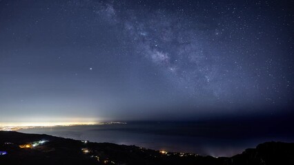 Wall Mural - time lapse of the starry night sky and the milky way rising over the glowing lights of los angles