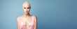 Young pretty bald woman with shaved head isolated on blue flat background with copy space. Baldness, alopecia areata from radiation therapy.