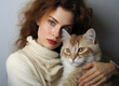 Portrait of young sensual redhaired woman holding white ginger long-haired cat in her arms