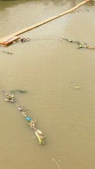 Wall Mural - Floating barrier to stop debris on the Ciliwung river. Jakarta, Indonesia.