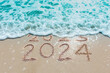 Message Year 2023 replaced by 2024 written on beach sand background. Good bye 2023 hello to 2024 happy New Year coming concept.