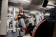© Dusan Petkovic - A sportswoman in shape is exercising with rowing machine in a gym.