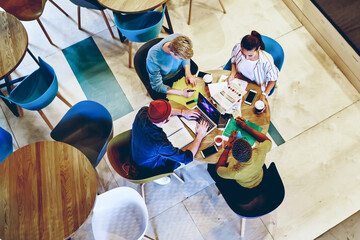 Top view of male and female group of students sitting in college campus prepare project together