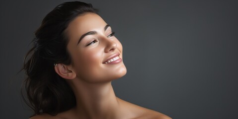 Wall Mural - a beautiful young woman with clean fresh skin, on gray background