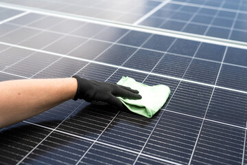 Wall Mural - male hand cleaning solar panels with towel to wipe dirty. Solar power for green energy