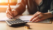 © Krisana - Business woman using calculator for do math finance on wooden desk in office.generative ai
