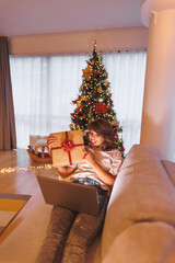 Wall Mural - Woman having video call showing Christmas present