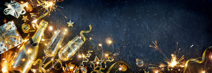 Wall Mural - new year celebration - champagne flutes and gift boxes with golden decoration and sparkler on shiny 