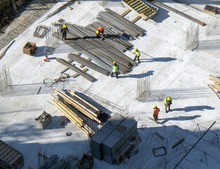 Wall Mural - Top view: workers doing job with a metal rebars at the construction site