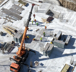 Wall Mural - Workers in orange and yellow uniform at the construction site on gray background