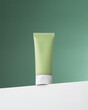 Trendy composition with bottle on podium. Bottle cosmetic tube on white podium on green background.  Cream bottle for branding and label. Concept of beauty care for the face.