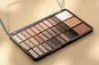 Colorful eyeshadow palette. Make-up palette over a beige background. Professional multicolor eye shadow makeup palette. Cosmetic products