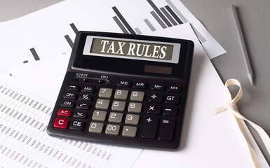 Poster - TAX RULES text on calculator with chart on grey background