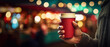 Hand with cup of hot drink at Christmas fair. Enjoying Christmas Market, blurred people in the streets and near stalls with bokeh light background. street evening city lights. 