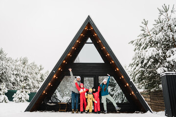 Big family with kids have fun on terrace of mountain country house in snow forest together. Company people childs celebrate New Year. Best friends in casual clothes spend winter holidays at cottage.