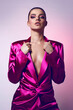 Beautiful young fashionable woman in a pink neon jacket and evening makeup. Fashionable woman, evening clothing style. Bright evening makeup, healthy tanned skin.