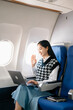 © Nuttapong punna - Young Asian executive excels in first class, multitasking with digital tablet, laptop and smartphone. Travel in style, work with grace. in morning light.