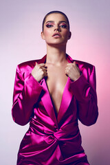 Wall Mural - Beautiful young fashionable woman in a pink neon jacket and evening makeup. Fashionable woman, evening clothing style. Bright evening makeup, healthy tanned skin.