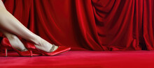 Woman Legs In Red Shoes On Red Velvet Background