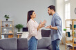© Studio Romantic - Emotional stressed young couple having argument at home. Portrait of angry irritated man and woman talking and looking at each other with annoyed. Relationship problems, family conflicts