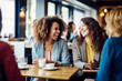 © Jasmina - Happy smiling female friends sitting in a café laughing and talking during a lunch break