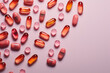 Different pills and capsules on pink background, flat lay