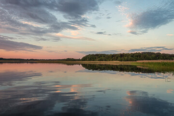 Sticker - Scenery of nature of Braslav lakes. Beautiful sunset on Snudy lake, the sky is overcast with small clouds. The sky is reflected from the surface of the lake water.