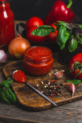 Wall Mural - Ketchup in a jar. Tomato sauce on a dark background