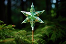 a sparkling paper star tree-topper on a green fir tree