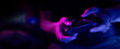 © ronstik - closeup of wireless video game controller in gamer hands in neon lights. banner with copy space