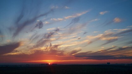 Wall Mural - The cloudy background enhances the vibrant colors of the sunset.