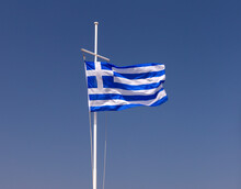 Greek National Flag Fluttering Against A Blue Sky.