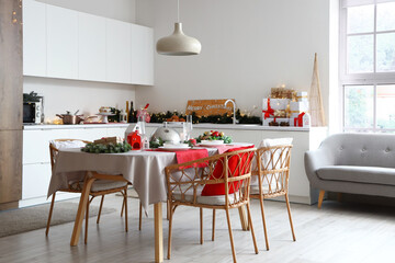 Interior of light kitchen with Christmas decorations and served table