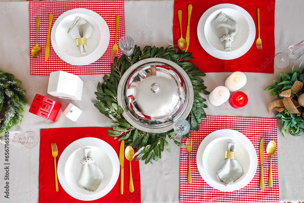 Christmas table setting with wreathes, decorations and cloche