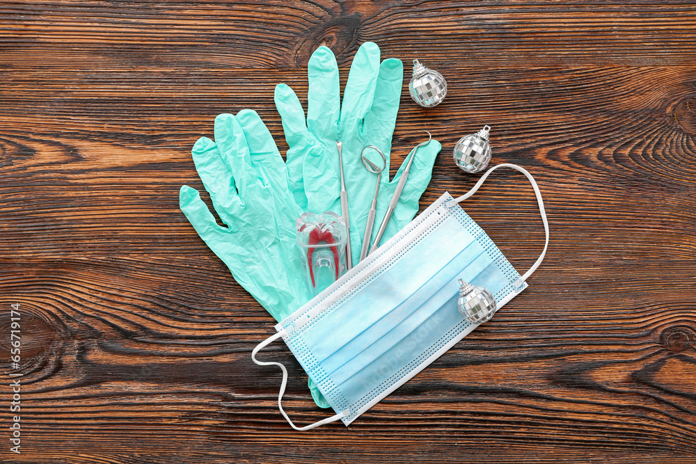Dentist's tools with Christmas decor on dark wooden background