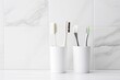 Toothbrushes on white countertop in bathroom